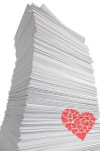 Giant looming stack of white paper with a red heart on the side
